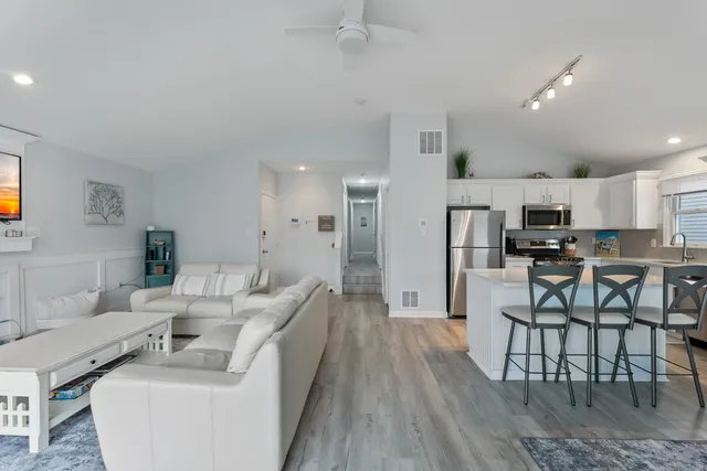a living room with furniture and kitchen view