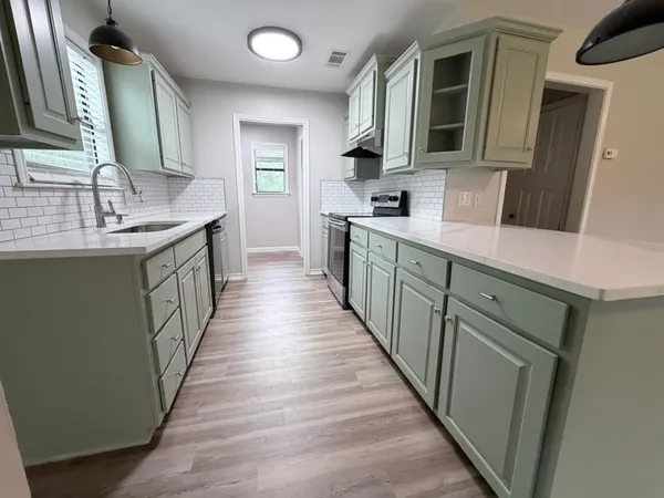 a kitchen with sink cabinets and wooden floor