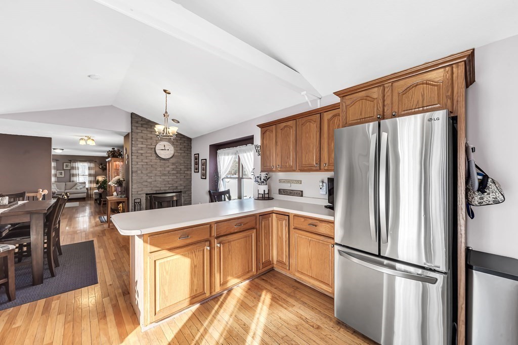 5 Pine Knoll Road Southwick, MA 01077 - Photo 11 of 40 a kitchen with granite countertop a refrigerator a sink dishwasher and white cabinets with wooden floor