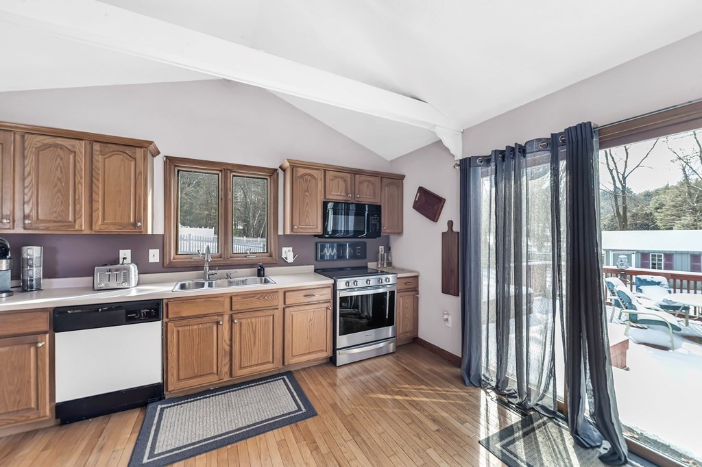 5 Pine Knoll Road Southwick, MA 01077 - Photo 13 of 40 a kitchen with stainless steel appliances granite countertop a stove top oven a sink dishwasher a refrigerator and cabinets with wooden floor