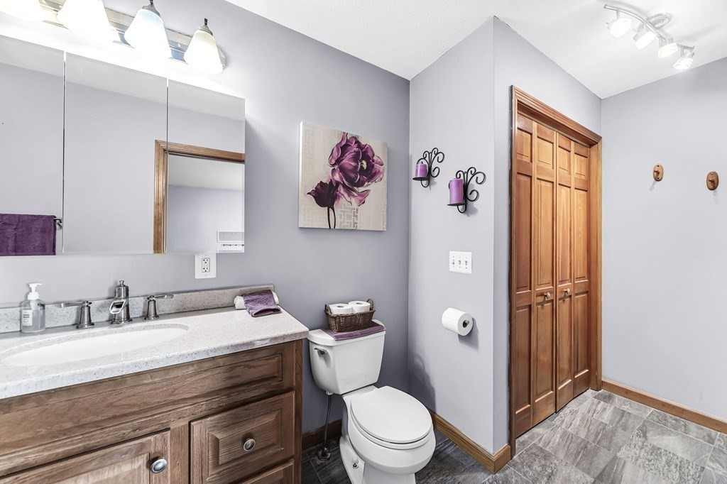 5 Pine Knoll Road Southwick, MA 01077 - Photo 24 of 40 a bathroom with a granite countertop toilet a sink and a mirror