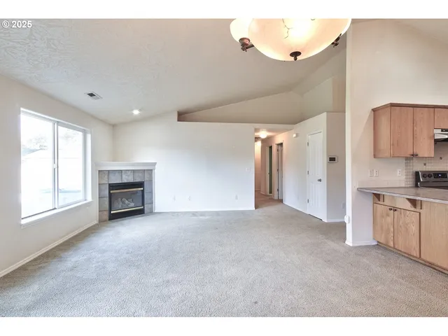 a view of empty room with a fireplace and window