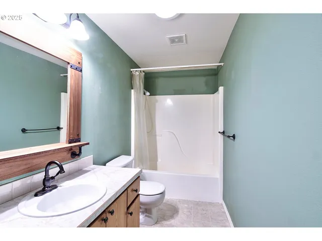 a bathroom with a granite countertop sink a mirror and a shower