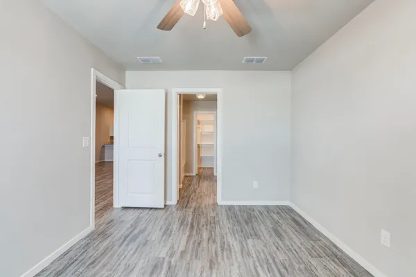 an empty room with wooden floor and closet