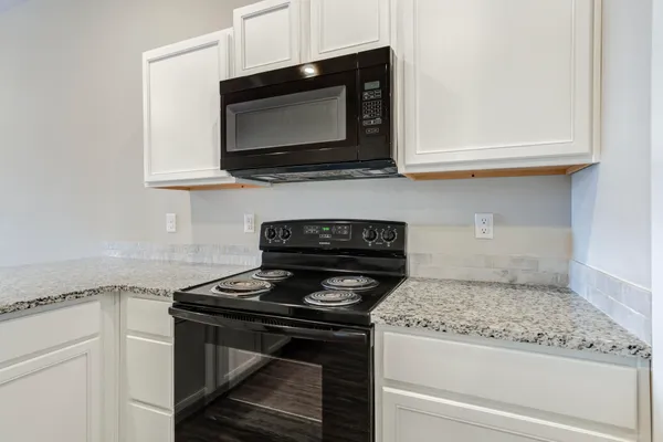 a kitchen with microwave cabinets and stove top oven