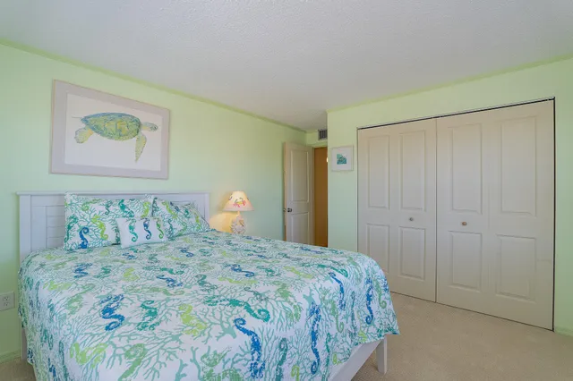 a bedroom with a bed and painting on the wall