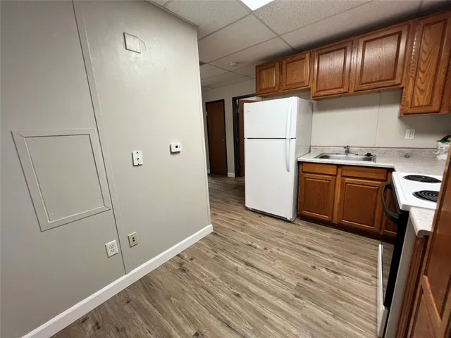 a kitchen with granite countertop a refrigerator a stove and a sink