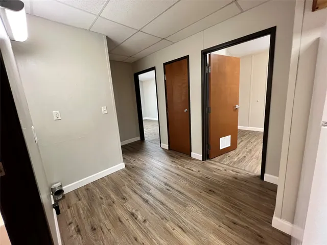 an empty room with wooden floor and entrance