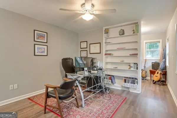a workspace with wooden floor a chandelier fan and windows