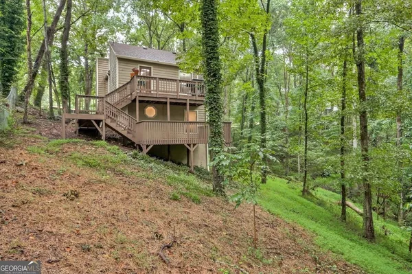 a view of a small house in middle of the forest