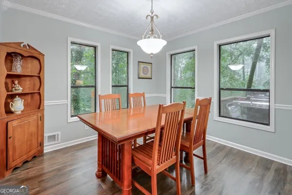 a dining room with furniture a chandelier and wooden floor