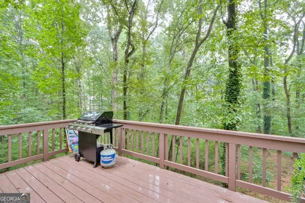 a view of roof deck with chairs and wooden fence