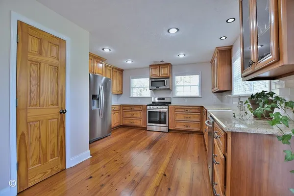 a kitchen with stainless steel appliances granite countertop wooden cabinets and a stove top oven