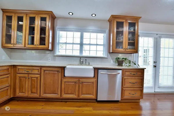 a kitchen with cabinets and wooden floor