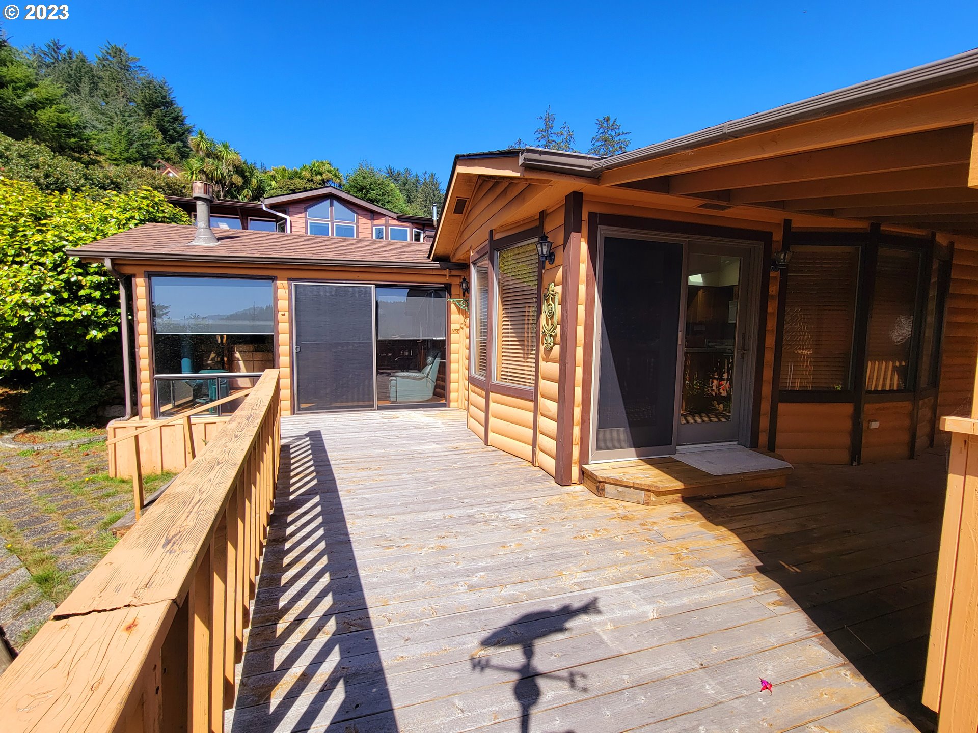 19921 Whaleshead Road, Unit OV8 Brookings, OR 97415 - Photo 11 of 48 a view of a house with a barbeque and wooden stairs