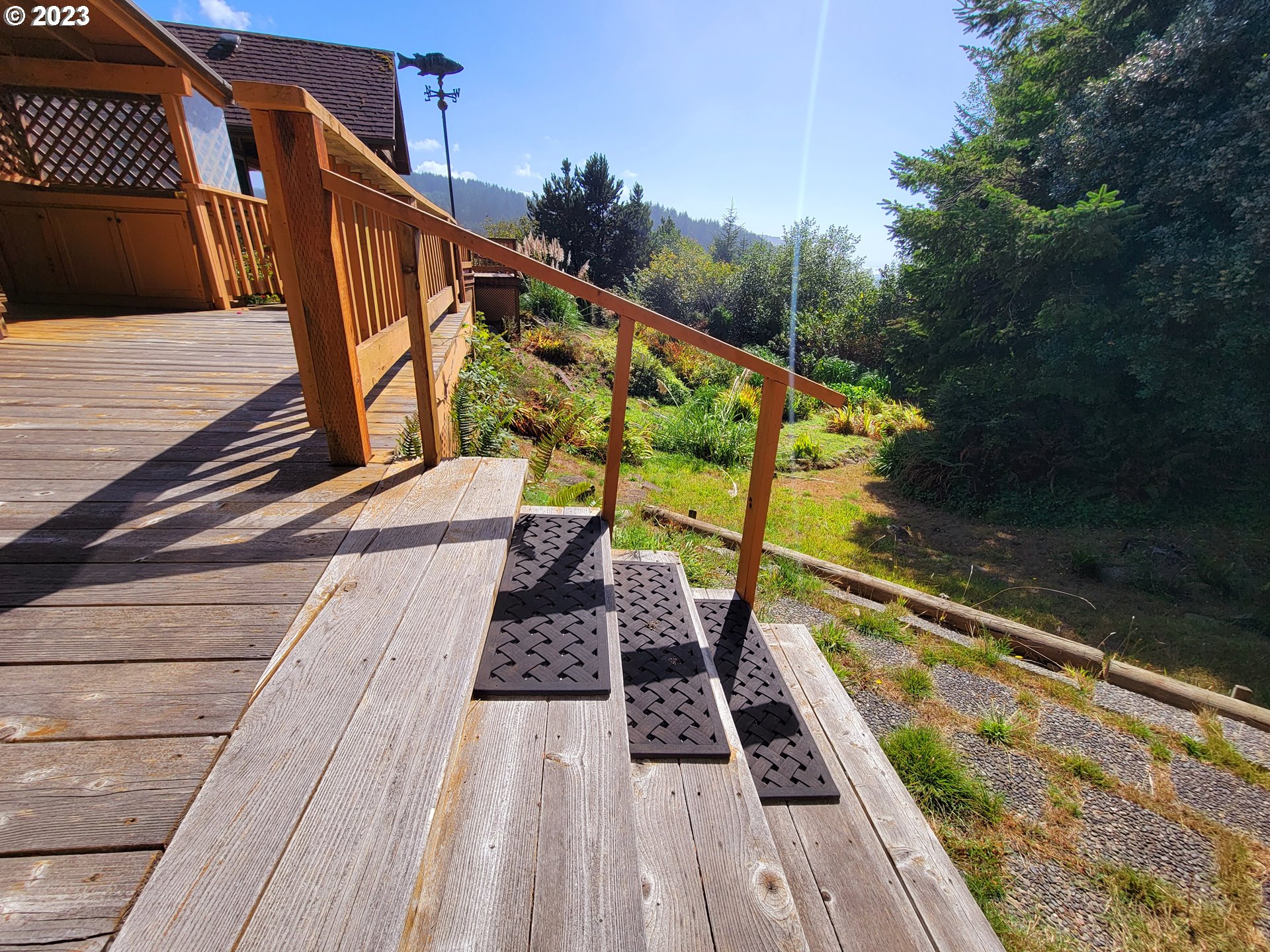 19921 Whaleshead Road, Unit OV8 Brookings, OR 97415 - Photo 15 of 48 a view of a balcony with two chairs and a wooden floor