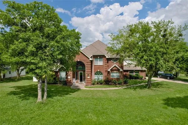 a front view of a house with a yard and trees