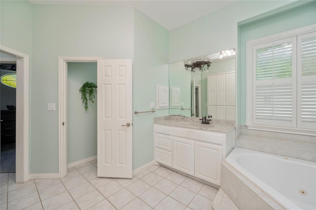135 Kirkpatrick Road Ennis, TX 75119 - Photo 18 of 40 a bathroom with a tub sink and mirror