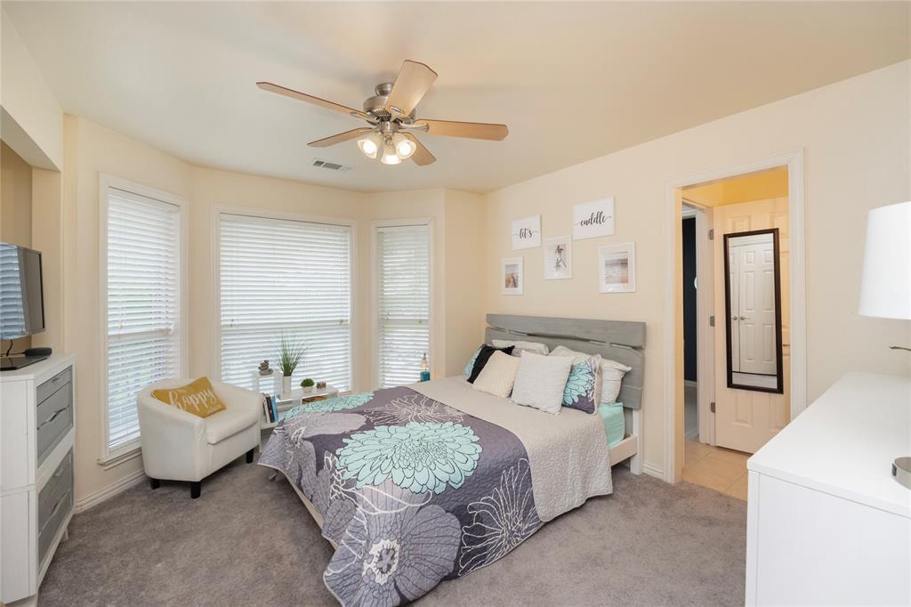 135 Kirkpatrick Road Ennis, TX 75119 - Photo 30 of 40 a bedroom with a bed and a chandelier