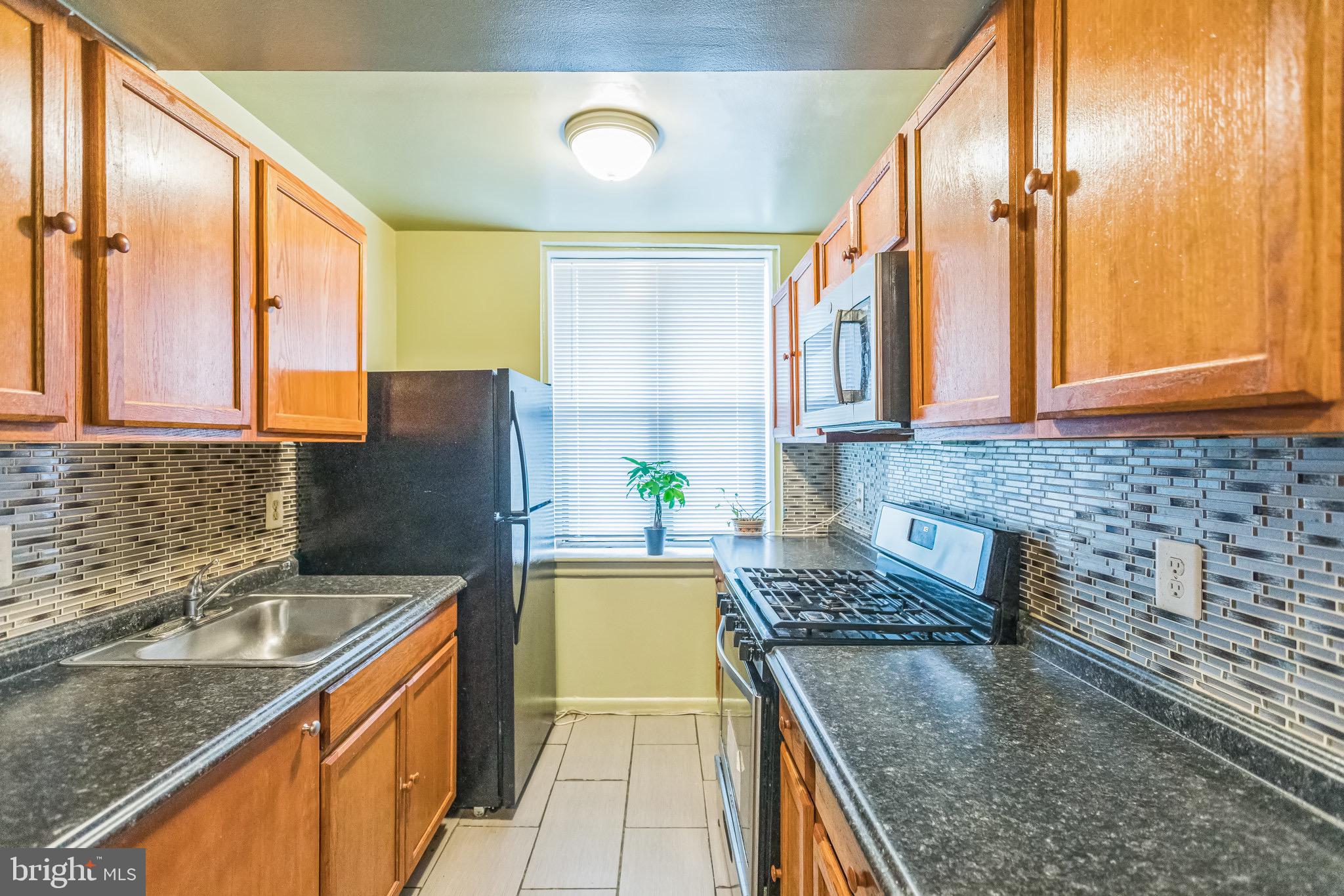 3902 14th Street Northwest, Unit 116 Washington, DC 20011 - Photo 7 of 14 a kitchen with stainless steel appliances granite countertop a sink stove and refrigerator