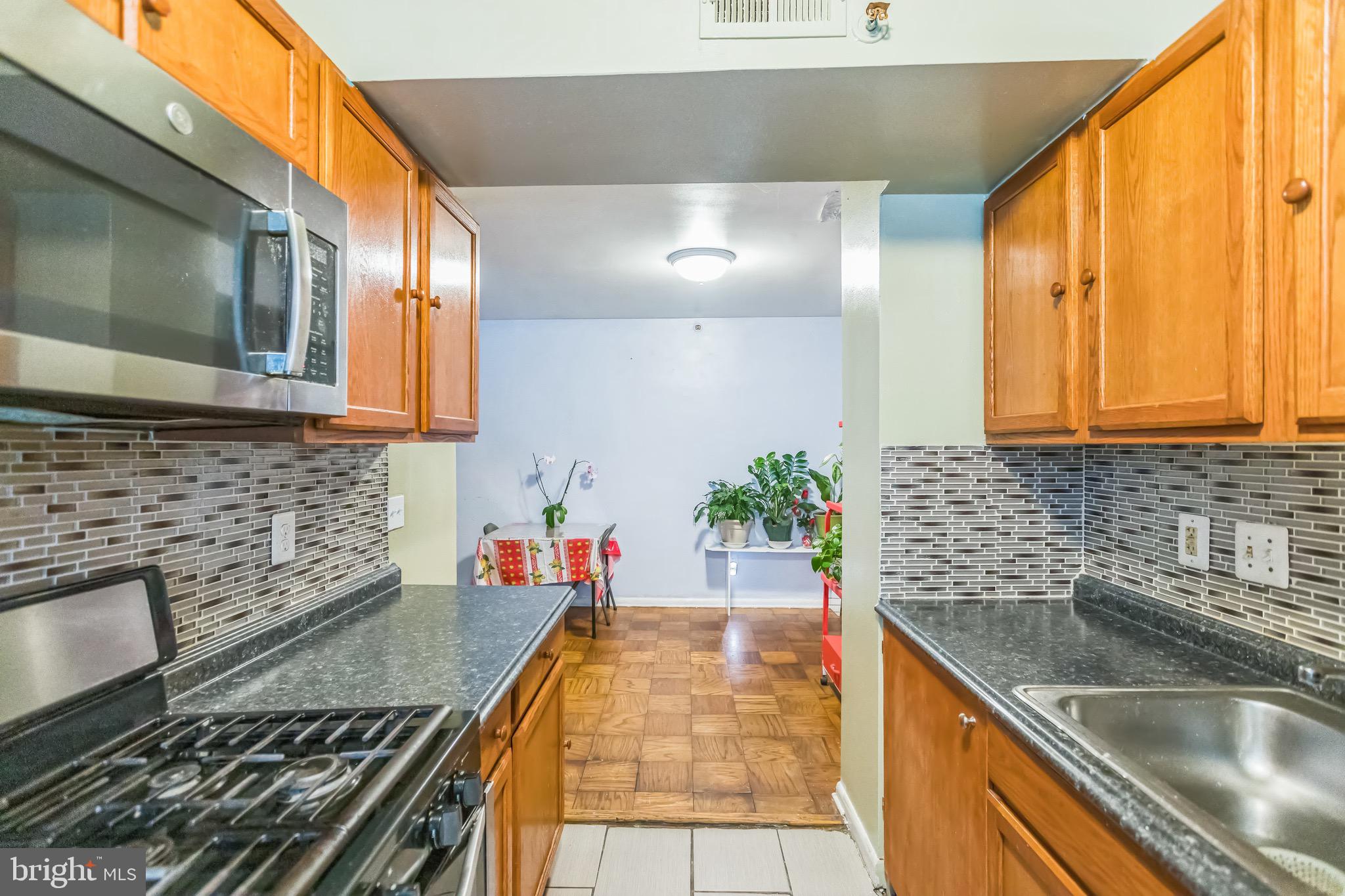 3902 14th Street Northwest, Unit 116 Washington, DC 20011 - Photo 8 of 14 a kitchen with stainless steel appliances granite countertop a sink stove and cabinets
