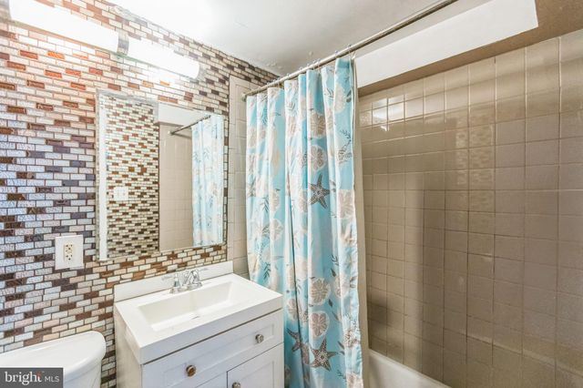 a bathroom with a sink mirror and shower
