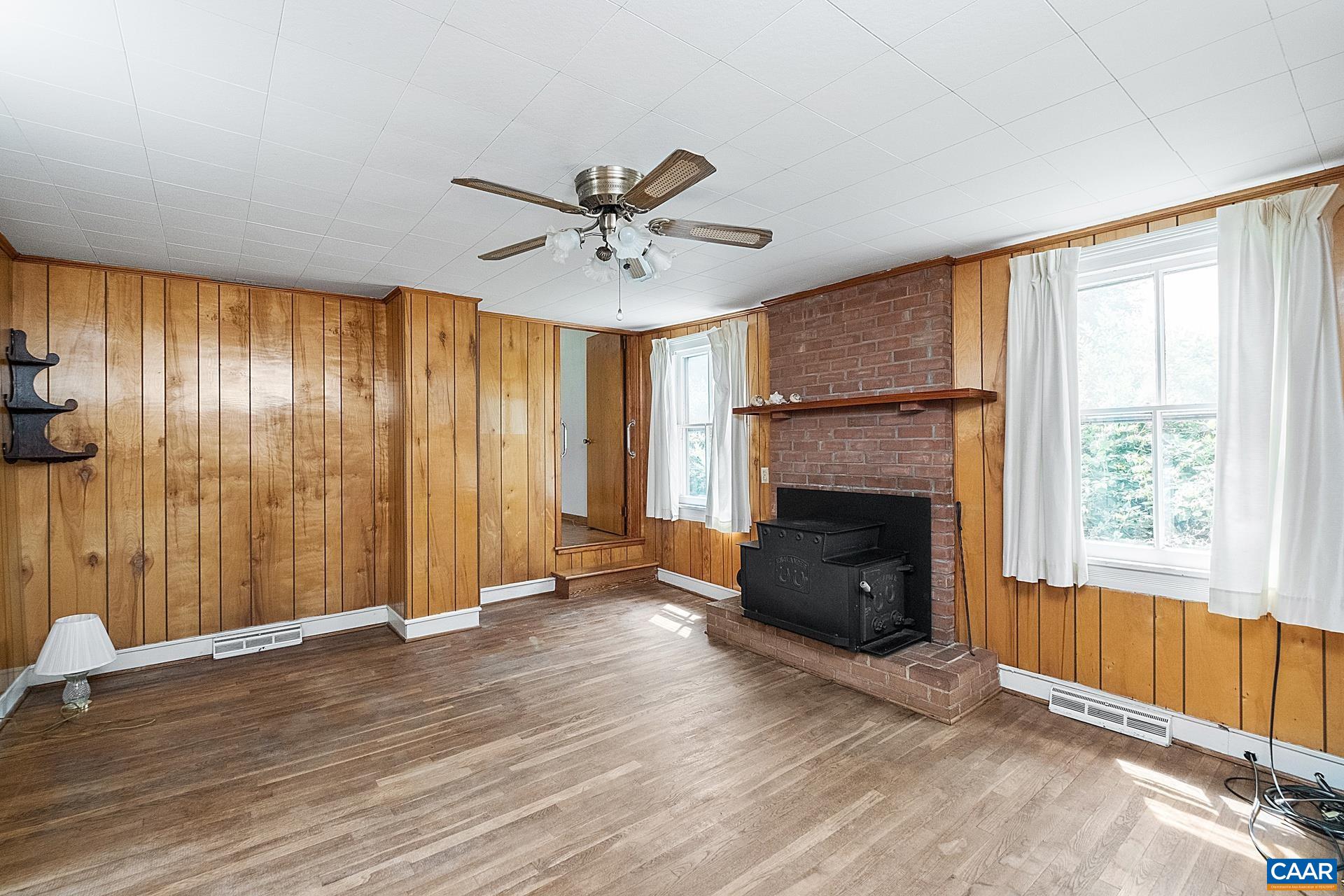 165 Shiloh Loop Faber, VA 22938 - Photo 17 of 33 an empty room with windows a fireplace and wooden floor