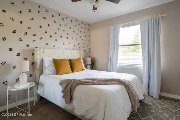 a bed sitting in a bedroom next to a window