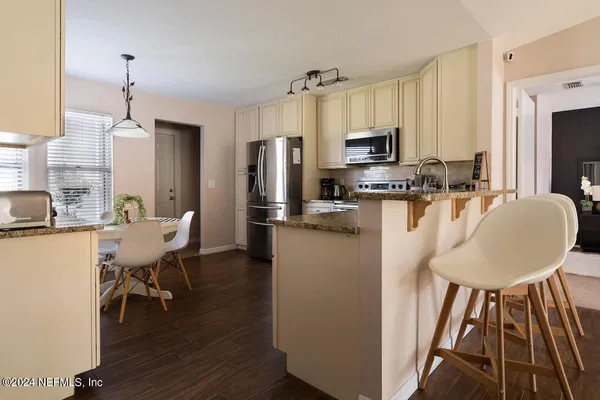 a kitchen with sink refrigerator dining table and chairs