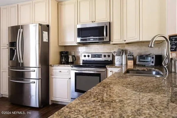 a kitchen with stainless steel appliances granite countertop a refrigerator stove and microwave
