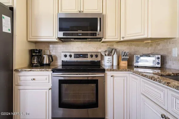 a kitchen with stainless steel appliances granite countertop a stove microwave and cabinets
