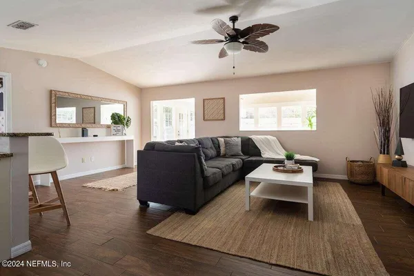 a living room with furniture flat screen tv and window