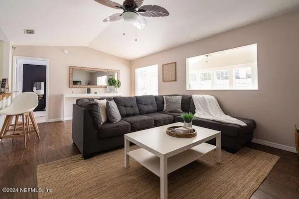a living room with furniture a wooden floor and a chandelier