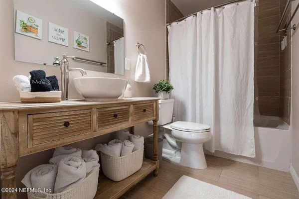 a bathroom with a toilet a sink and curtain