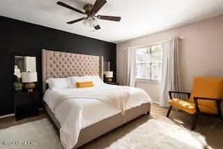 a bedroom with a bed mirror and a window