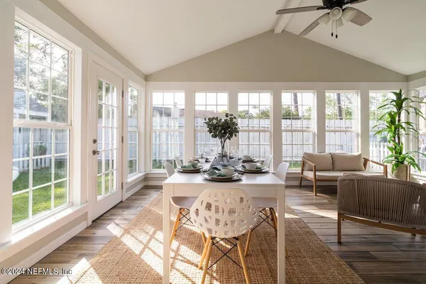 a living room with furniture and floor to ceiling windows
