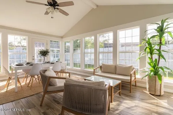 a living room with furniture and a large window with wooden floor
