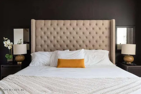 a bedroom with a bed and a lamp