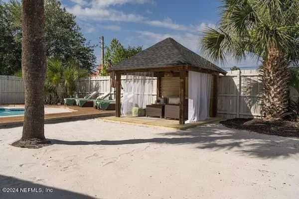 a view of a chair and table in backyard of the house