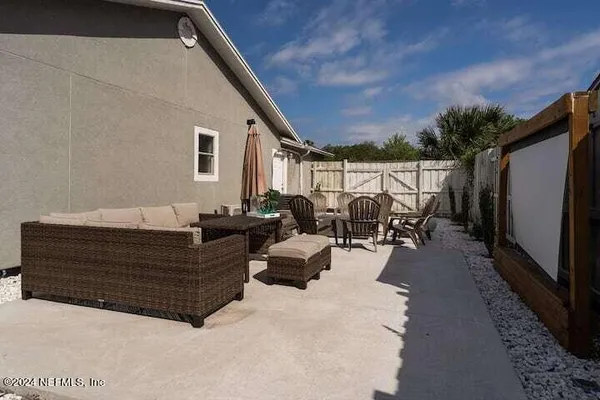 a view of a patio with table and chairs with wooden fence