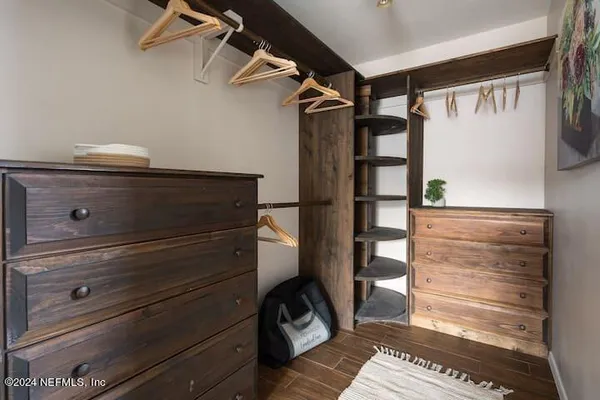 a view of walk in closet with clothes and shoes