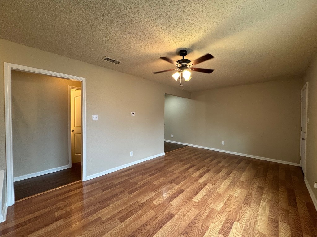 4904 West Wind Trail, Unit 102 Austin, TX 78745 - Photo 3 of 23 wooden floor in an empty room with a window