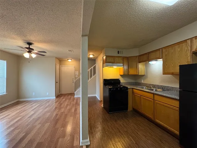 a kitchen with stainless steel appliances granite countertop a refrigerator a sink and a stove