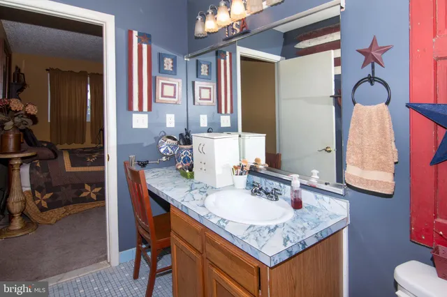 a bathroom with a granite countertop sink and a mirror