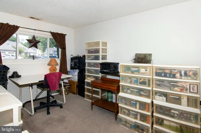 a view of a workspace with furniture and a window