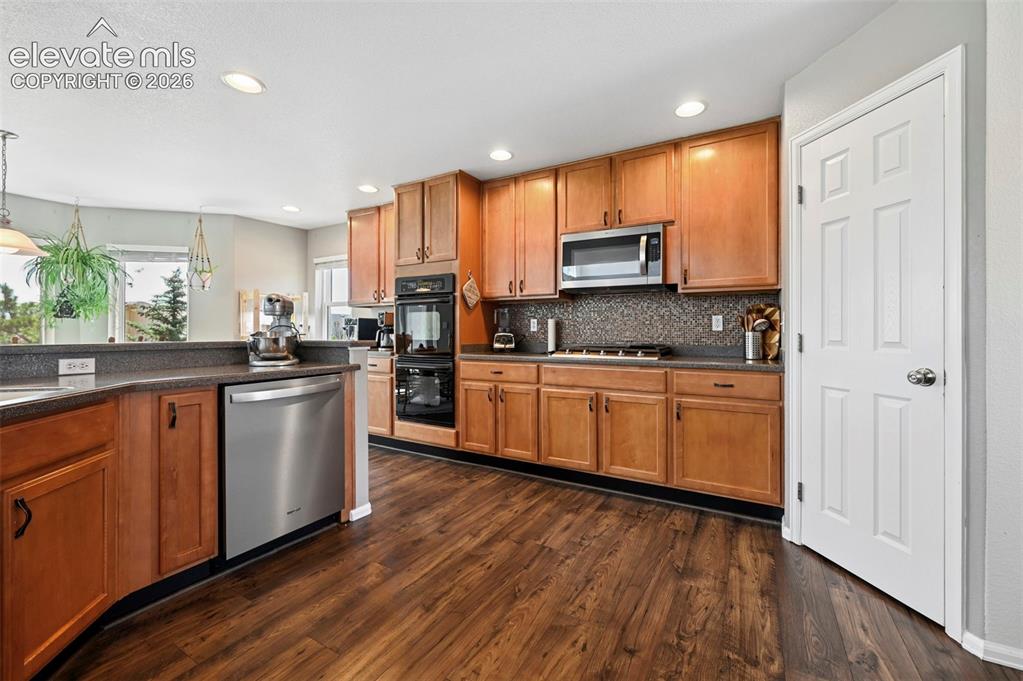 10643 Pictured Rocks Drive Peyton, CO 80831 - Photo 8 of 37 a kitchen with stainless steel appliances a refrigerator sink and microwave