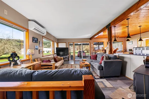 a living room with furniture a fireplace and large windows
