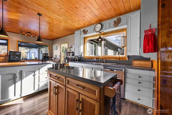 a kitchen with granite countertop a sink a counter space appliances and cabinets