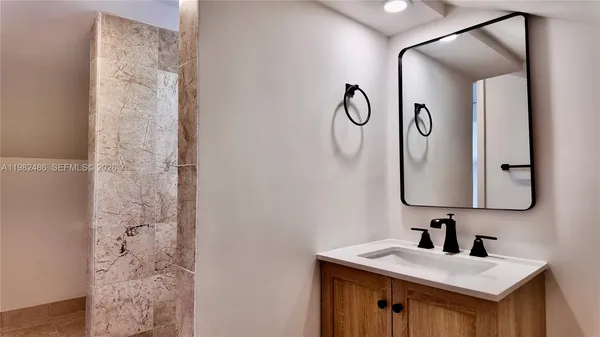 a bathroom with a sink vanity and a mirror