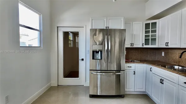 a kitchen with stainless steel appliances granite countertop a refrigerator and a stove